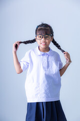 Girl in Thai school uniform,Portrait lovely Asian student girl in Thai school uniform pointing finger up isolated on pink background.