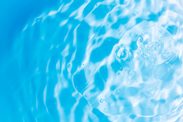 Blue water surface,Transparent blue clear water surface texture with ripples, splashes and bubbles. Abstract nature background Water waves in sunlight. Cosmetic moisturizer micellar toner emulsion. 