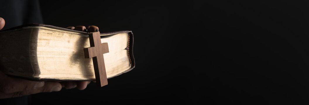 prayer man holding Bilbe with cross