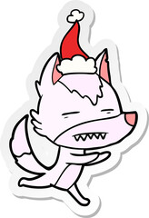 hand drawn sticker cartoon of a wolf showing teeth wearing santa hat