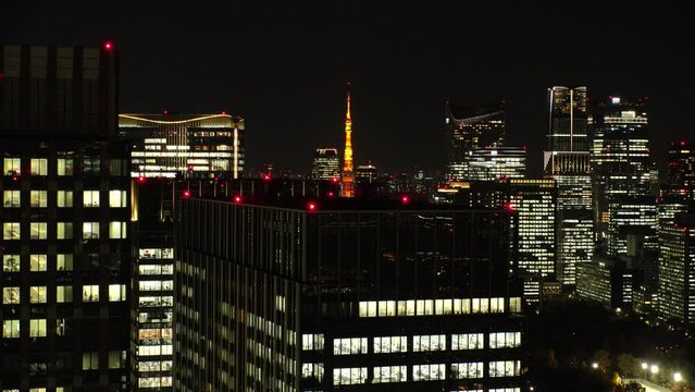 TOKYO, JAPAN - NOV 2023 : Close up shot of crowded office buildings at night. Japanese business, real estate, company, labour and work concept video.