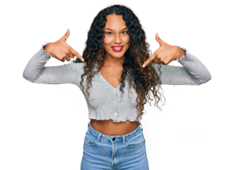 Young hispanic woman with curly hair wearing casual clothes looking confident with smile on face, pointing oneself with fingers proud and happy.