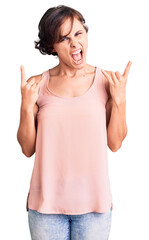 Beautiful young woman with short hair wearing casual style with sleeveless shirt shouting with crazy expression doing rock symbol with hands up. music star. heavy concept.