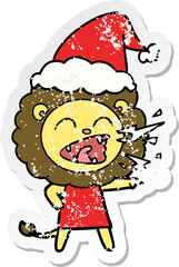 hand drawn distressed sticker cartoon of a roaring lion girl wearing santa hat