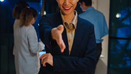 Portrait of successful executive businesswoman smart casual wear shaking hands and looking at...