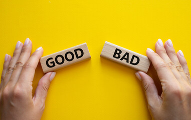 Good or Bad symbol. Concept word Good or Bad on wooden blocks. Businessman hand. Beautiful yellow...