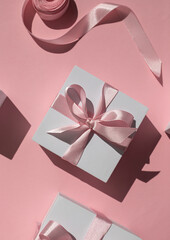 White gift boxes on the pink background. Top view