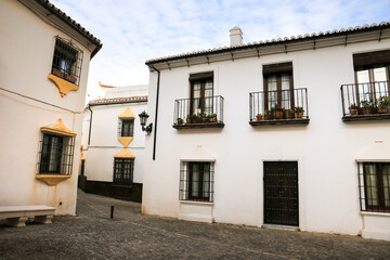 Fototapeta na wymiar Narrow cobblestone streets and whitewashed facades of Ronda city