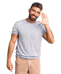 Young hispanic man wearing casual clothes waiving saying hello happy and smiling, friendly welcome gesture © Krakenimages.com