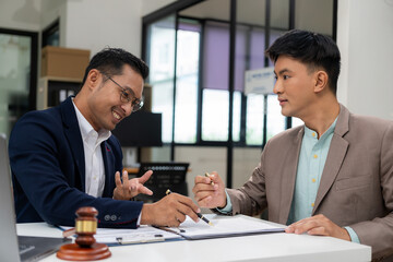 Lawyers are discussing contract terms and explaining to successful business people there are contracts to protect. Signing a small agreement