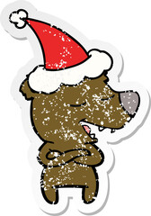 hand drawn distressed sticker cartoon of a bear wearing santa hat