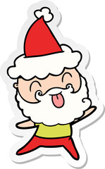 man with beard sticking out tongue wearing santa hat