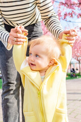 Sweet moment of a mother helping her son take his first steps.