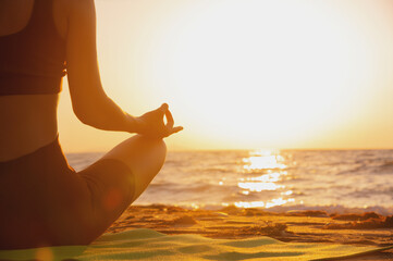 Close up of woman's hand practicing yoga, meditation in lotus position on the beach, feeling so...