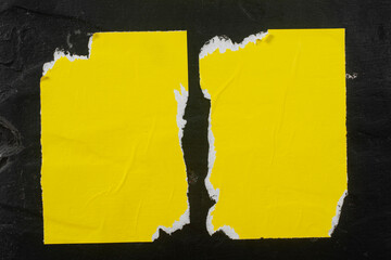 Two torn yellow sheets of paper with folds.