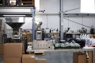 Background image of coffee roastery workshop with machines and packages, copy space