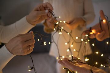 A family is unraveling a New Year's Christmas garland.
