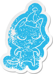 calm quirky cartoon distressed sticker of a cat wearing santa hat