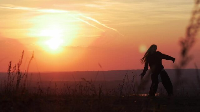 Girl dancing on the background of the sunset. moving shot