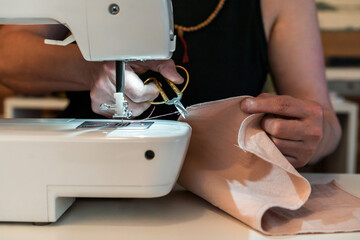 Close up pf woman cutting a thread while working with a sewing machine