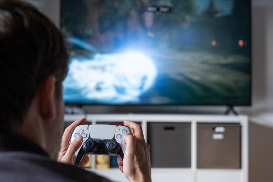 A man playing with a computer game on a big screen.
