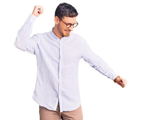Handsome young man with bear wearing elegant business shirt and glasses dancing happy and cheerful, smiling moving casual and confident listening to music