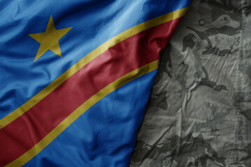 waving flag of democratic republic of the congo on the old khaki texture background. military concept.