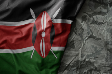 waving flag of kenya on the old khaki texture background. military concept.