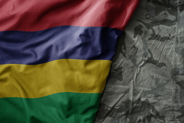 waving flag of mauritius on the old khaki texture background. military concept.