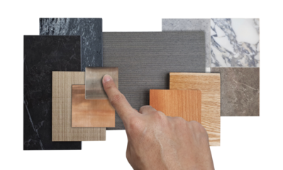 interior architect selects material samples including laminated, wooden engineer flooring, veneer, black stone quartz, stainless, marble ceramic stone tiles isolated on background with clipping path.