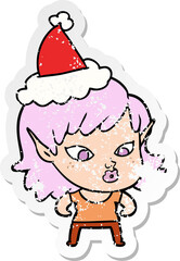 pretty hand drawn distressed sticker cartoon of a elf girl wearing santa hat