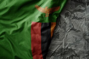 waving flag of zambia on the old khaki texture background. military concept.