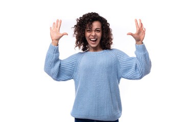 young confident lady with black curly hair dressed in a light blue sweater on a white background. people lifestyle concept