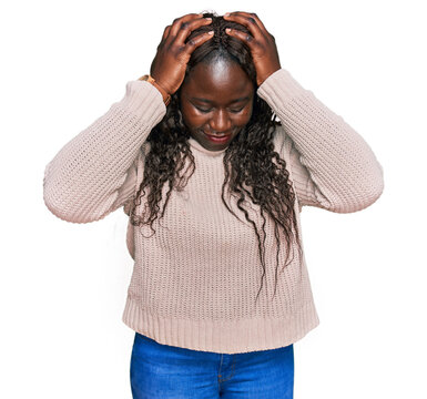 Young african woman wearing wool winter sweater suffering from headache desperate and stressed because pain and migraine. hands on head.