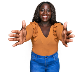 Young african woman wearing casual clothes looking at the camera smiling with open arms for hug. cheerful expression embracing happiness.