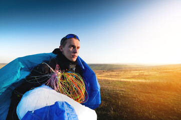 guy holds the lines of a paraglider in his hands close-up. A male paraglider carries a paraglider...