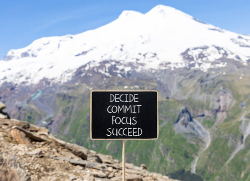 Decide commit focus succeed symbol. Concept word Decide Commit Focus Succeed on beautiful blackboard. Beautiful mountain Elbrus background. Business decide commit focus succeed concept. Copy space.