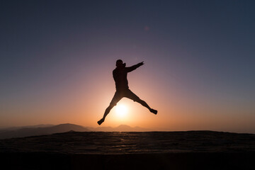 Fototapeta na wymiar star jumping over the sun, man silhuette at sunrise, Nemrut, Turkey