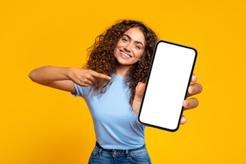 Happy woman pointing at blank smartphone screen