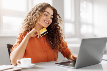 Happy shopper with credit card ready to buy online