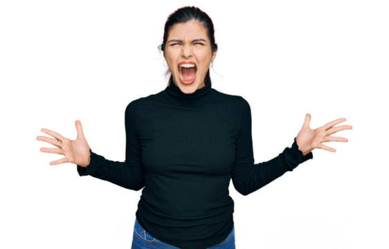 Young hispanic woman wearing casual clothes crazy and mad shouting and yelling with aggressive expression and arms raised. frustration concept.
