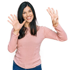 Young hispanic woman wearing casual clothes showing and pointing up with fingers number nine while smiling confident and happy.