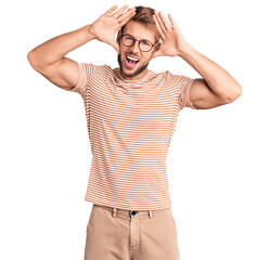 Young caucasian man wearing casual clothes and glasses smiling cheerful playing peek a boo with...