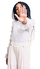 Cute african american girl wearing casual white tshirt doing stop sing with palm of the hand. warning expression with negative and serious gesture on the face.