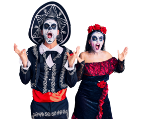 Young couple wearing mexican day of the dead costume over background crazy and mad shouting and yelling with aggressive expression and arms raised. frustration concept.