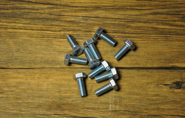 group of metal bolts on a wooden background. blur