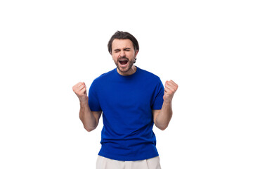 Fototapeta premium emotional young brunette man with a beard dressed in a blue t-shirt on a white background