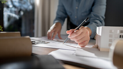 Architects interior designer hands working with Blue prints and documents for a home renovation for house design.
