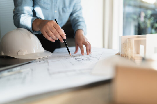 Interior architect or engineer working on blueprint at home office.