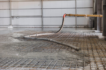 Building site with pipe with concrete of pump truck , Iron frame for foundation floor. Closeup reinforced structures, knitting of metal reinforcing cage